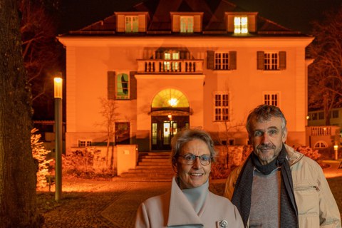 Rector Staudinger and Vice-Rector Kobel stand in front of the rectorate illuminated in orange. By doing so, the rectorate joins Orange the Day to raise awareness of violence against women