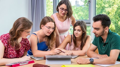 Fünf Studierende gemeinsam an einem Tisch im Gespräch