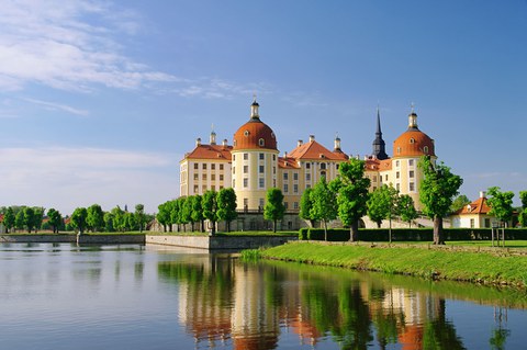 The picture shows the castle 'Schloss Moritzburg' near Dresden during summer. In front there is also a lake.