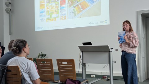 Zu sehen ist Anja Rogas, die einen Vortrag im Festsaal vor Lehrkräften hält 