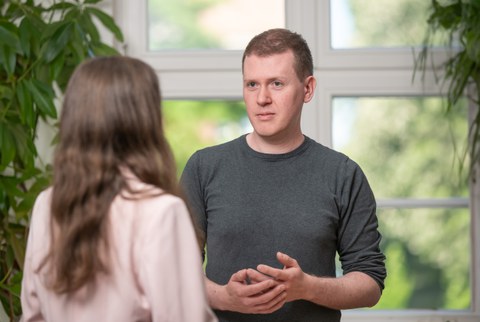 Man sieht einen Mann, der seinem Gegenüber aufmerksam zuhört.