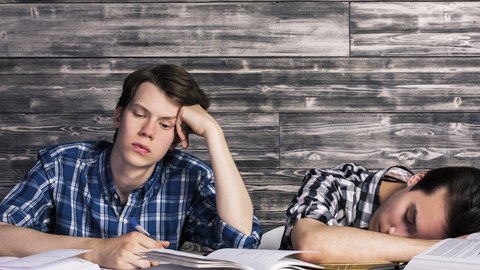 Zwei müde Studenten am Schreibtisch