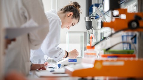 Fotoaufnahme von einer Frau, die in einem Labor arbeitet.