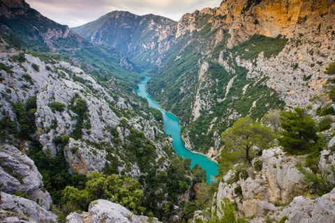 A mediterranean mountain landscape crossed by a turquoise river