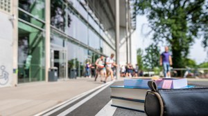 The photo shows the auditorium centre of the TU Dresden. The focus is on two books and a pencil case. They are lying on the stairs in front of the lecture hall centre.