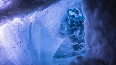 Zu sehen ist eine Welle aus Eis, durch die man hindurchschauen kann.