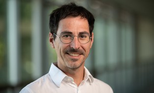 Dunkelhaariger Herr mit Brille