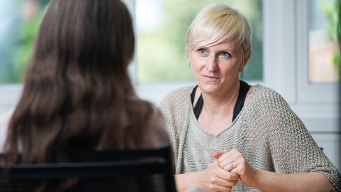 You see a woman listening attentively to her counterpart.