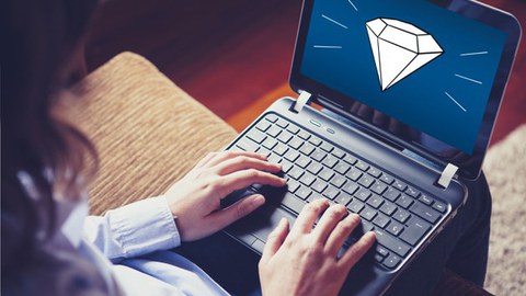 Person sitting on a couch typing on a laptop; a diamond icon is displayed on the screen.