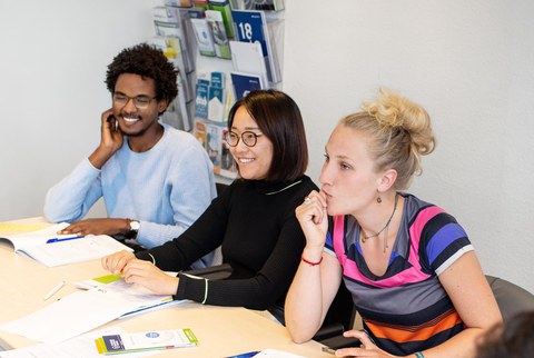 Foto von drei lächelnden Studenten im Career Service Workshop an der TU Dresden. 