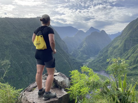 TUD student at a viewpoint overlooking a green mountain landscape