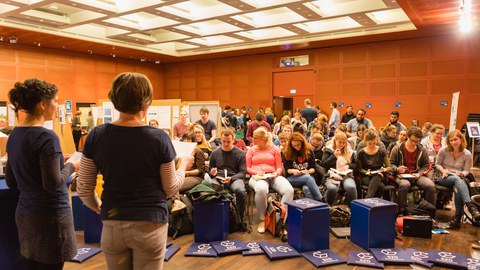 Nina Melching und Ulrike Samuelsson begrüßen die Teilnehmenden zur Langen Nacht des Schreibens im Klemperer-Saal der SLUB.