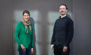 You can see Antonia Zacharias-Weihs and Konrad Schrötter. They are smiling at the camera and are illuminated by the sun. It's the group photo of the summer university team.