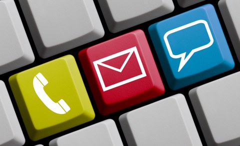Das Foto zeigt die Nahaufnahme einer Tastatur. Drei nebeneinanderliegende Tasten sind unterschiedlich eingefärbt und mit den Symbolen Telefon, Brief und Sprechblase versehen.