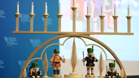 Das Foto zeigt einen aus Holz gefertigten Chanukka-Leuchter im Stil eines erzgebirgischen Schwibbogens.